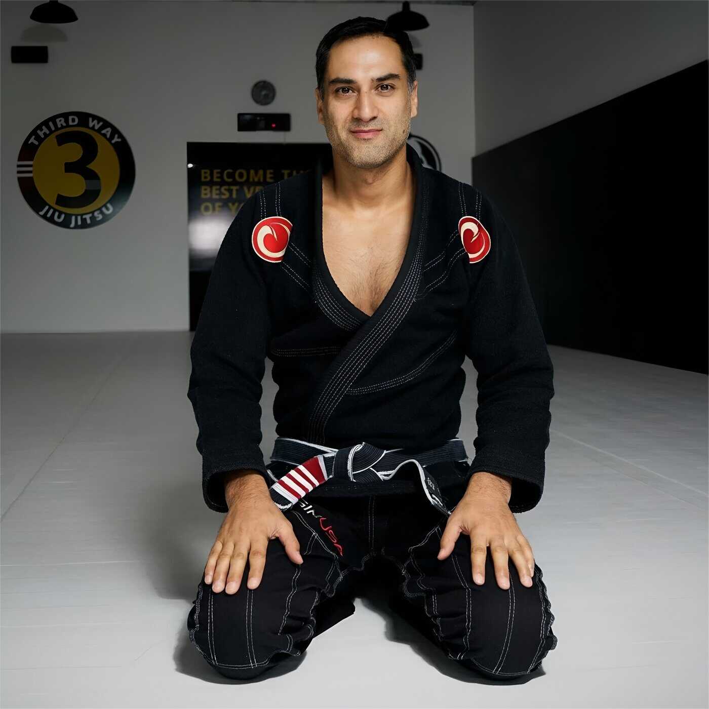 Roy Dean, Brazilian Jiu-Jitsu black belt instructor, kneeling on the mat at a BJJ training camp